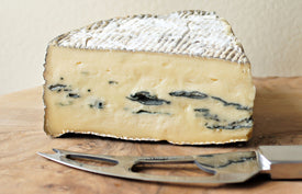 cote hill blue cheese on a wooden paxton and whitfield cheeseboard with cheese knife