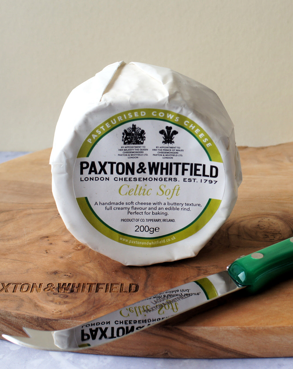 celtic soft cheese on a wooden paxton and whitfield cheeseboard with cheese knife