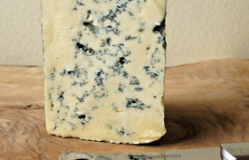 detail close up of cashel blue cheese on a wooden paxton and whitfield wooden cheeseboard with cheese knife