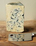 detail close up of cashel blue cheese on a wooden paxton and whitfield wooden cheeseboard with cheese knife