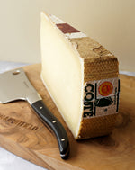 Comté androuet cheese on wooden paxton and whitfield cheeseboard with cheese knife 