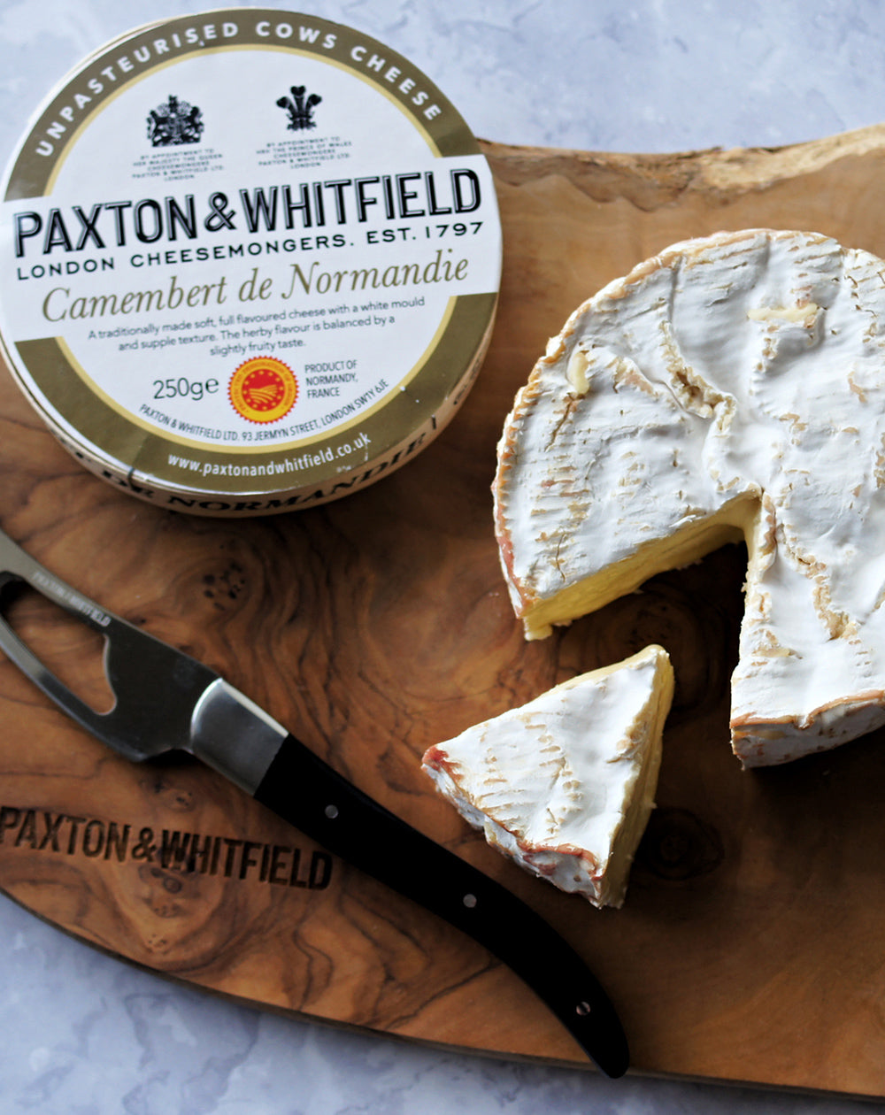 camebert de normandie on paxton and whitfield cheese board with cheese knife