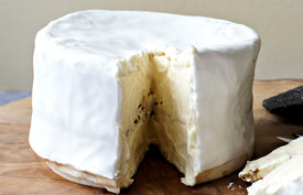 close up of brillat savarin affine on paxton and whitfield wooden cheeseboard 