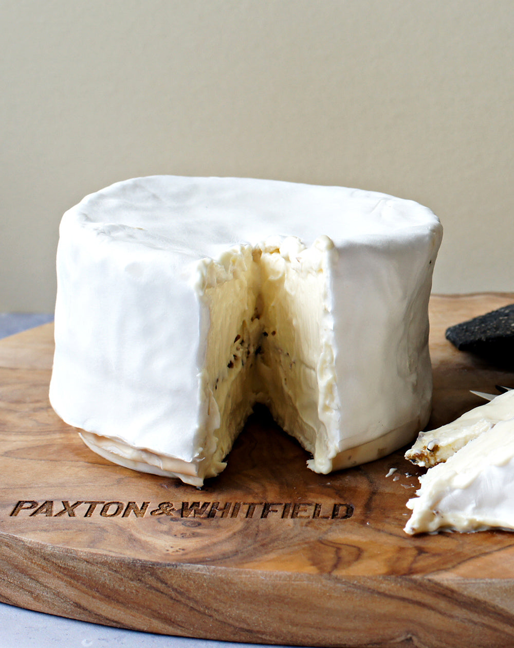 close up of brillat savarin affine on paxton and whitfield wooden cheeseboard 