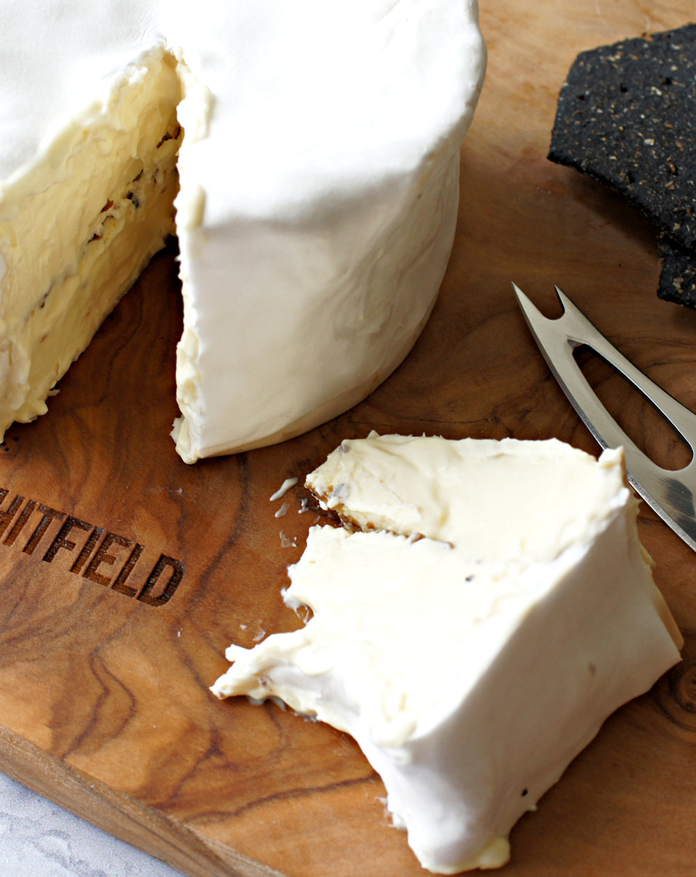 detail close up of brillat savarin on paxton and whitfield wooden cheeseboard