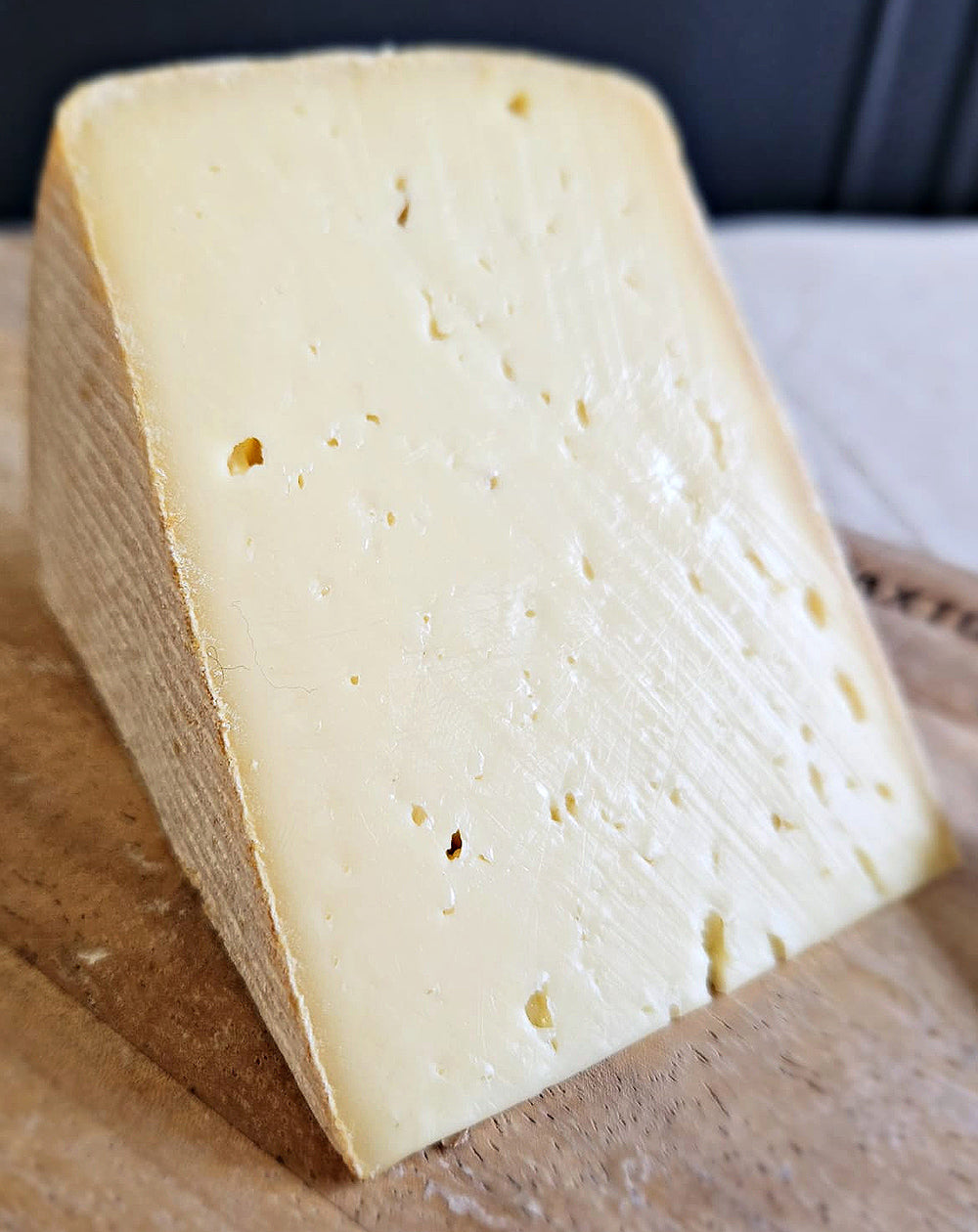 close up of corinium cheese on wooden cheeseboard