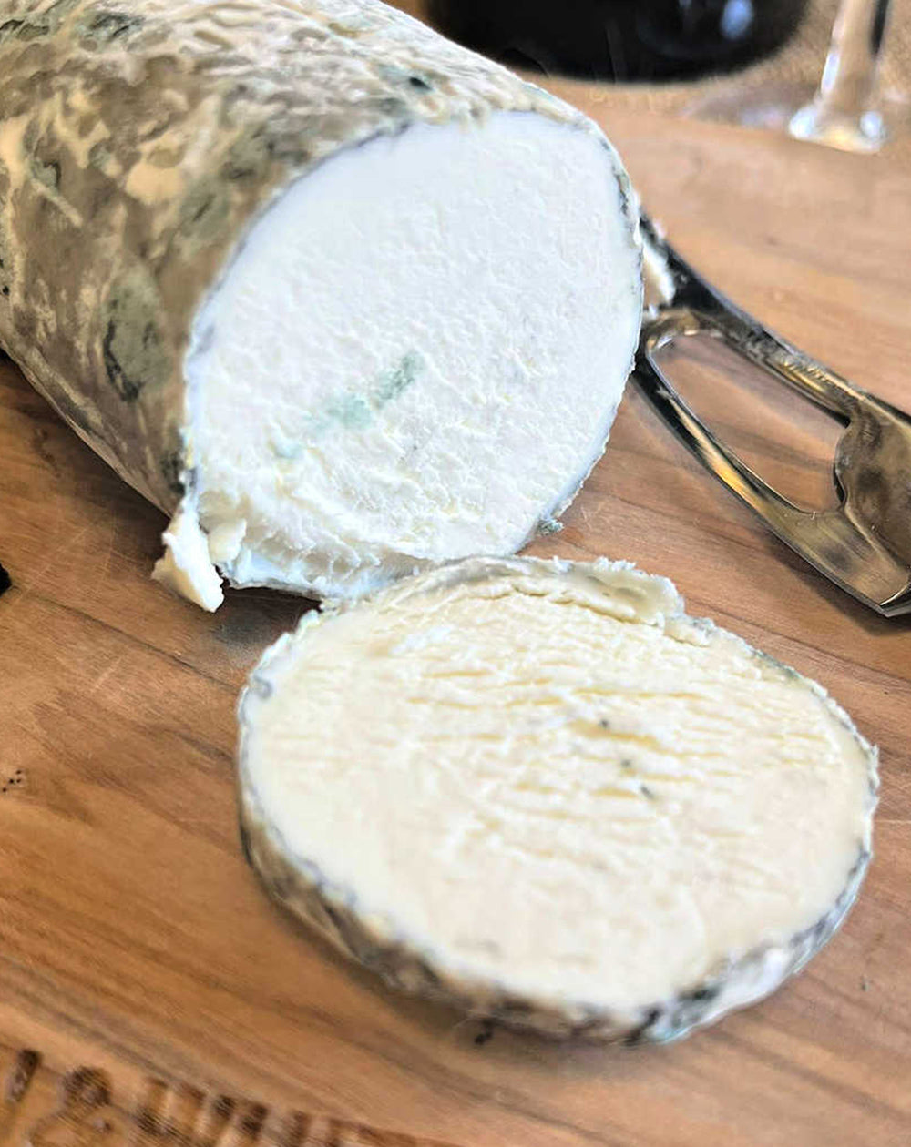 close up of elrick log cheese on paxton and whitfield wooden cheeseboard