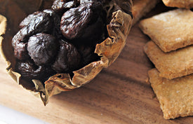 opened up paxton and whitfield fig ball showing figs inside on a wooden cheeseboard