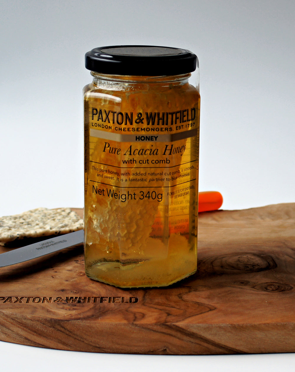 close up of acacia honey jar on paxton and whitfield wooden cheeseboard